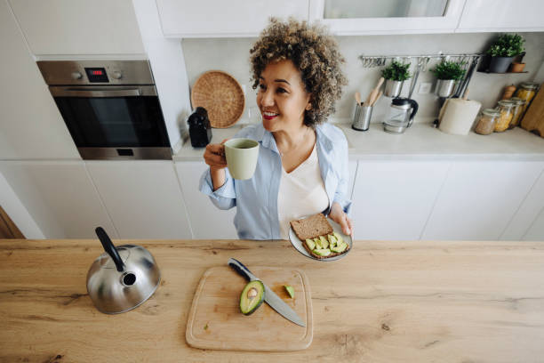 istock Woman making coffee and avocado sandwich for breakfast 2162152770