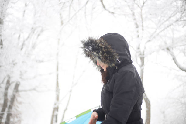 Smiling woman wearing scarf in a winter cold day. Happy girl in a sweater outdoor in snow. Beautiful smiling woman with hat and scarf outdoor looking away.