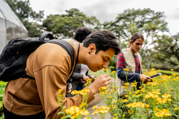 istock Young man smelling flowers at nature park 2162155011