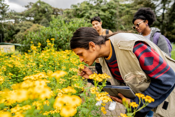 istock Tour guide smelling flowers at nature park 2162155014