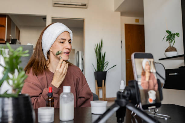 istock Woman vlogging makeup tutorial recording on mobile phone at home 2162155898