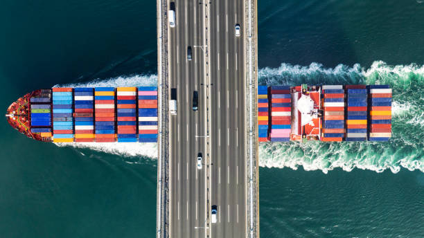 Aerial view of a cargo ship passing under bridge. Cargo Ship Beneath Bridge.