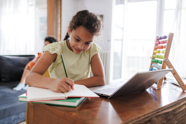 istock Young Girl Writing Notes - Online Learning with a Smile 2162157437