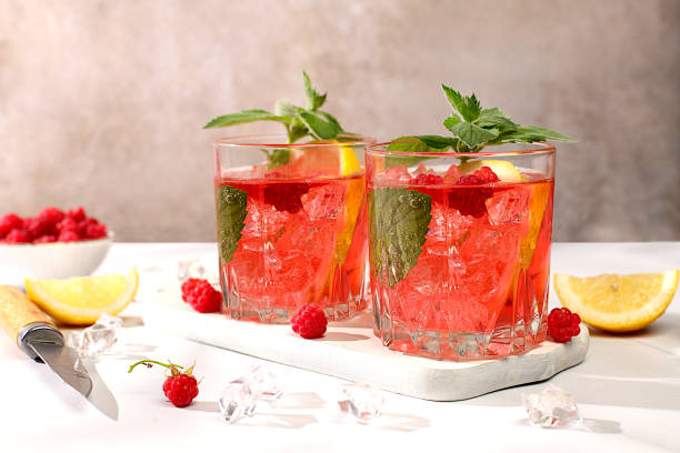istock Lemonade cocktail,mojito with tequila, gin, rum, vodka, liqueur, lime, ice and fresh raspberries, bar and party concept, restaurant and cafe advertising card, black background, selective focus. 2162161274