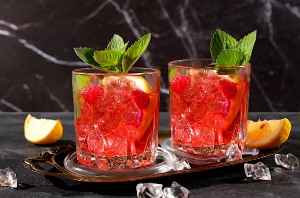 istock Lemonade cocktail,mojito with tequila, gin, rum, vodka, liqueur, lime, ice and fresh raspberries, bar and party concept, restaurant and cafe advertising card, black background, selective focus. 2162161331