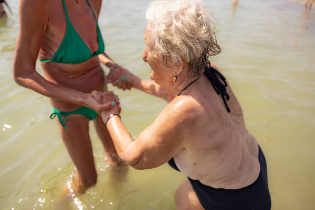istock Senior Lady in Swimsuit Assisted 2162162449