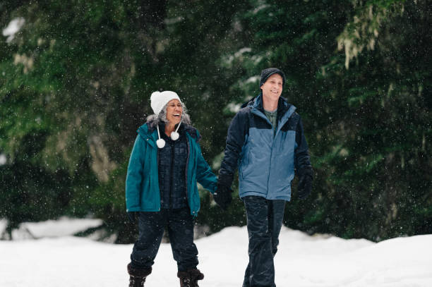 Senior couple holds hands while snowshoeing