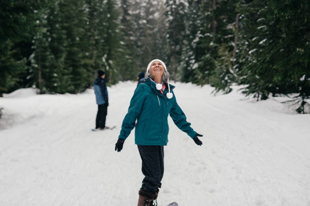 Senior woman smiles while snowshoeing