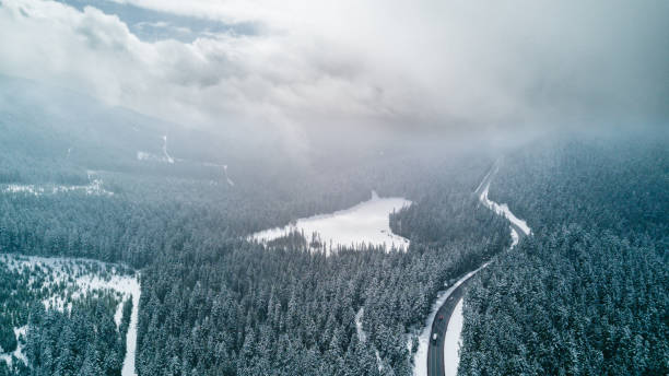 istock Aerial view of highway going through snowy forest 2162163057