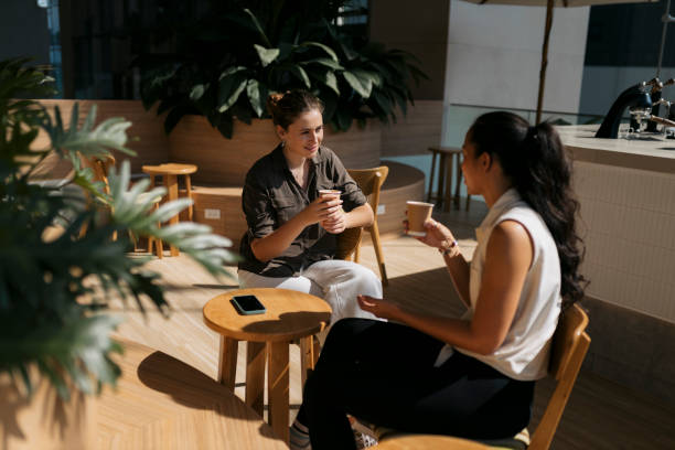istock Two friends indulge in a lively conversation over refreshing coffee at modern cafe 2162163372