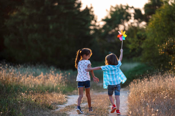 istock Kids with a pinwheel on a natural path, joyfully playing 2162166170