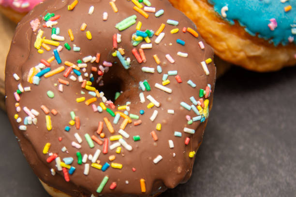 Delicious dessert. Pink, blue and chocolate donuts with multicolored sprinkles.