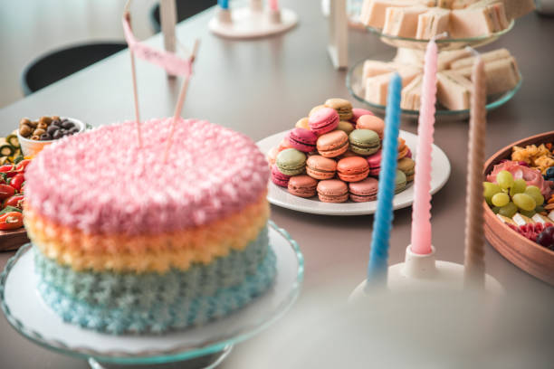 Fluffy birthday cake with a candle on pink and soft balloon surface.