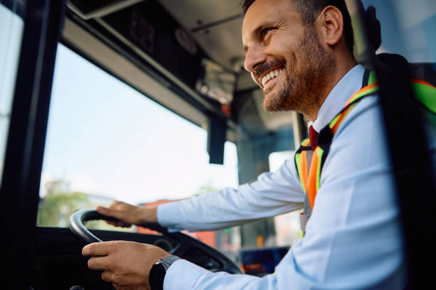 istock Happy driver driving public bus through the city. 2162176995
