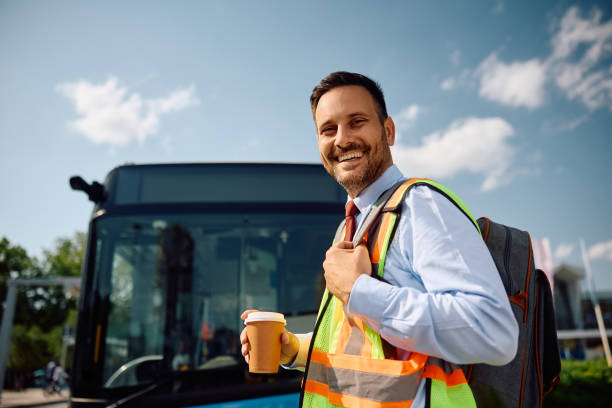 istock Happy bus driver with takeaway coffee coming to work at looking at camera. 2162177005