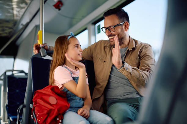 istock Happy father and daughter giving high-five while riding in public transport. 2162177146