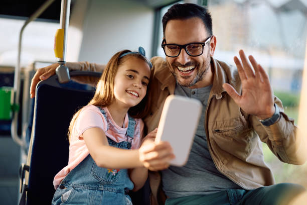 istock Happy father and daughter having fun while talking selfie in a bus. 2162177186