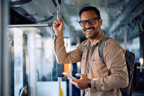 istock Happy man texting on mobile phone while commuting by bus and looking at camera. 2162177196