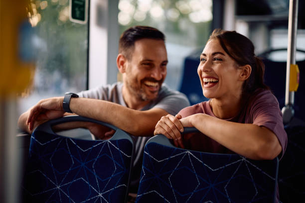Happy couple enjoying while commuting by city bus.