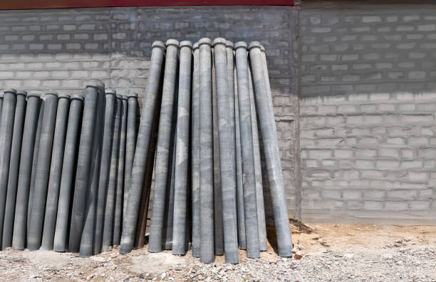 Asbestos cement pipes for drain arrange on warehouse wall.