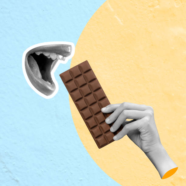 A human hand eats a chocolate bar