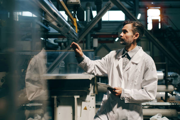 istock Man with tablet working with industrial machine at factory 2162194682