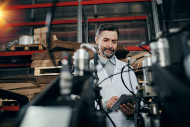 istock Engineer working at the factory surrounded with machinery, checking equipment 2162194722