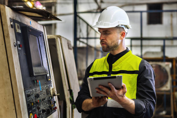 istock man in a yellow vest is looking at a tablet while wearing a hard hat 2162195458