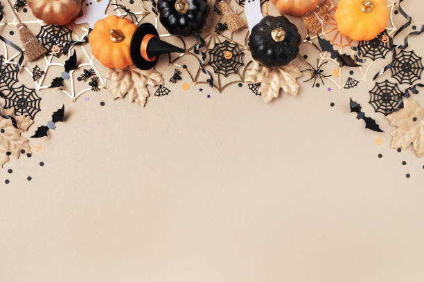 istock Halloween holiday frame with party decorations from pumpkins, bats, spider web and ghosts top view. Happy halloween greeting card on golden background top view. 2162198668