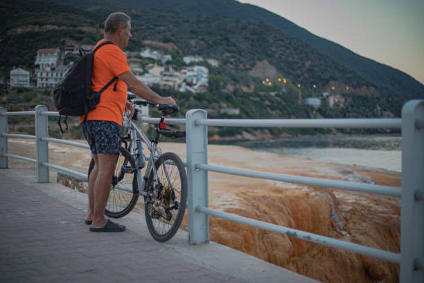 A tourist with a bicycle explores the seashore