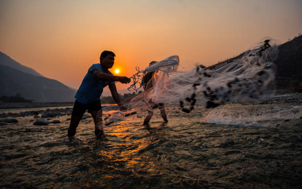 Rural people practicing traditional fishing methods in the Tamakoshi River in Manthali, Nepal, on  Saturday March 10, 2024