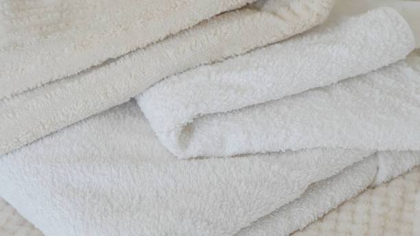 istock White and beige towels neatly stacked, adding a touch of elegance and comfort 2162201103