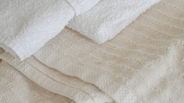 istock White and beige towels neatly stacked, adding a touch of elegance and comfort 2162201104