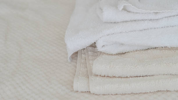 istock White and beige towels neatly stacked, adding a touch of elegance and comfort 2162201501