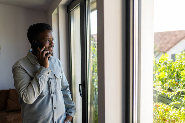 istock Young man using smartphone in living room at home 2162201946