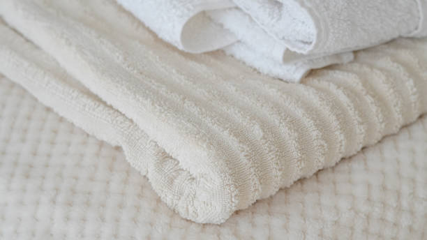 istock White and beige towels neatly stacked, adding a touch of elegance and comfort 2162201977