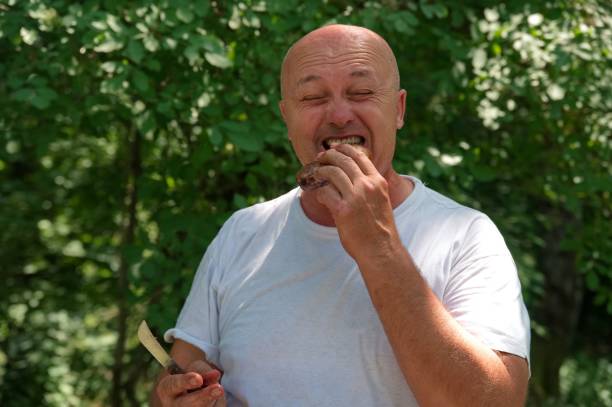 senior man wants to eat chocolate and orange cream dessert - plain background
