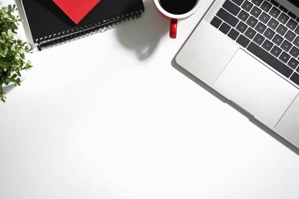 istock White office desk with a cup of coffee, laptop and notebook. Top view with copy space 2162203454
