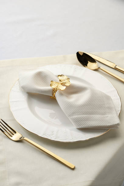 istock Gold Leaf Napkin Ring on White Plate and Placemat 2162205139