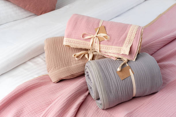 istock Rolled Up Soft Pink and Grey Muslin Blankets on Bed 2162205817