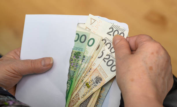 istock Pensioner holds money in an envelope, close-up 2162206590