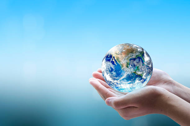 istock World environment day concept: Human hands holding the earth globe over blurred blue sea with bokeh background. Elements of this image furnished by NASA 2162208959
