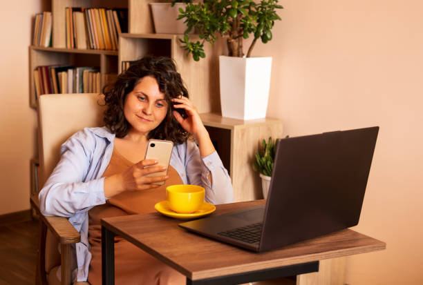 istock Beautiful woman using smartphone and laptop. 2162212325