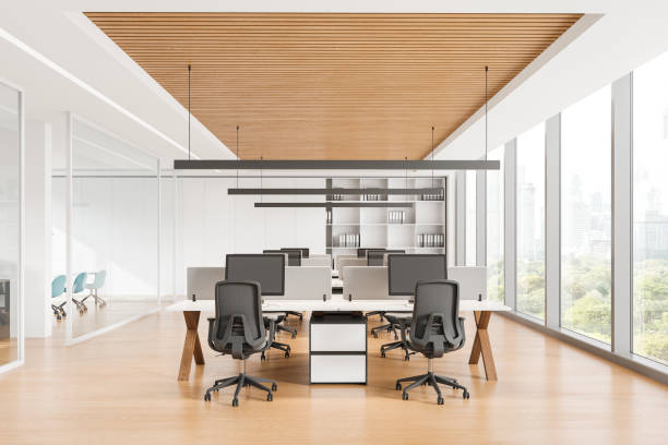 istock Modern office interior with workstations and computers, bright lighting, wood and white finish. Concept of workspace.  3D Rendering 2162212420