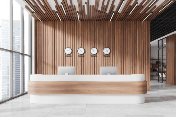 Modern reception desk with computers, clocks on wooden wall, office interior, business concept.  3D Rendering
