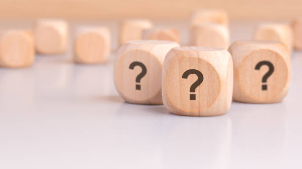 istock three wooden blocks with question marks over a gray background with copy space 2162214674