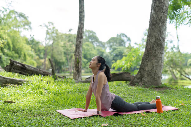 istock Young Woman Practicing Yoga Outdoors in a Serene Garden Setting, Relaxing and Connecting with Nature on a Sunny Day 2162222016