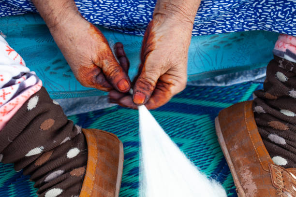 Close-up of a native Hispanic woman's skilled hands knitting with colorful wool yarn, showcasing traditional craftsmanship in Ecuadorian culture