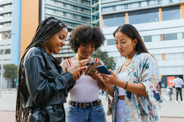 istock Multi-ethnic friends using phone standing in the city 2162222792