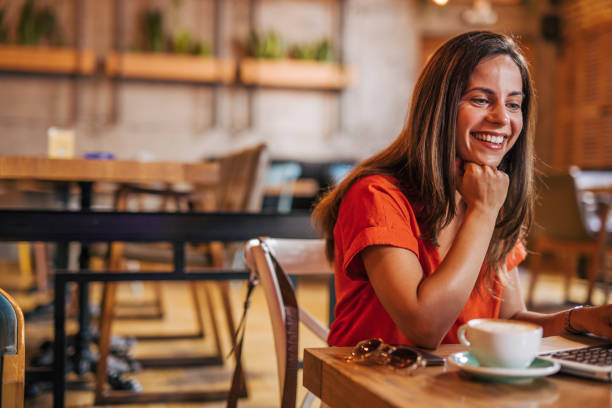 istock young woman is sitting in a cafe and using laptop for online work 2162224418